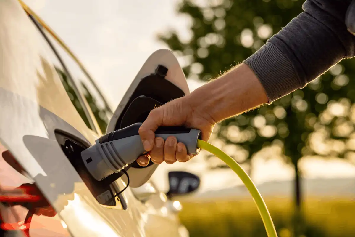 Close up of hands charging electric vehicle